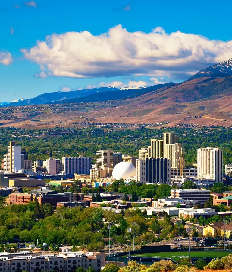 Downtown Reno skyline, Nevada, with hotels, casinos and the surrounding High Eastern Sierra foothills